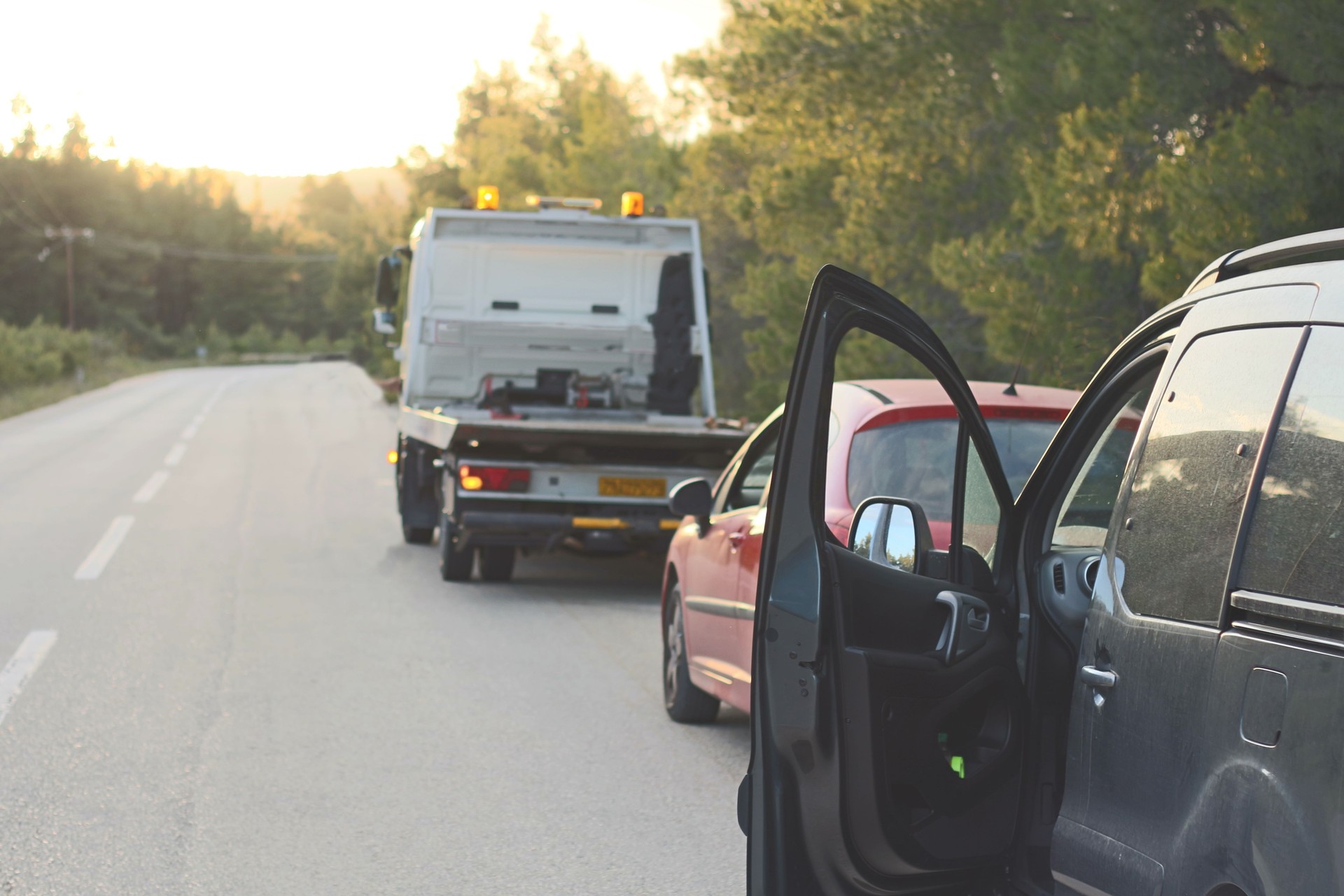 Car Breakdown with Towing Vehicle on Roadside and Warning Triangles