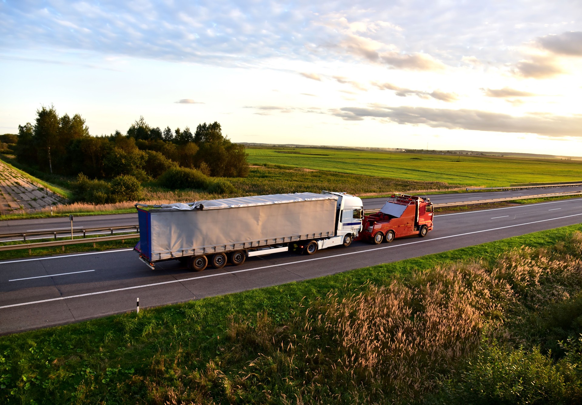 Heavy Recovery Truck Tows a Semitrailer truck on highway