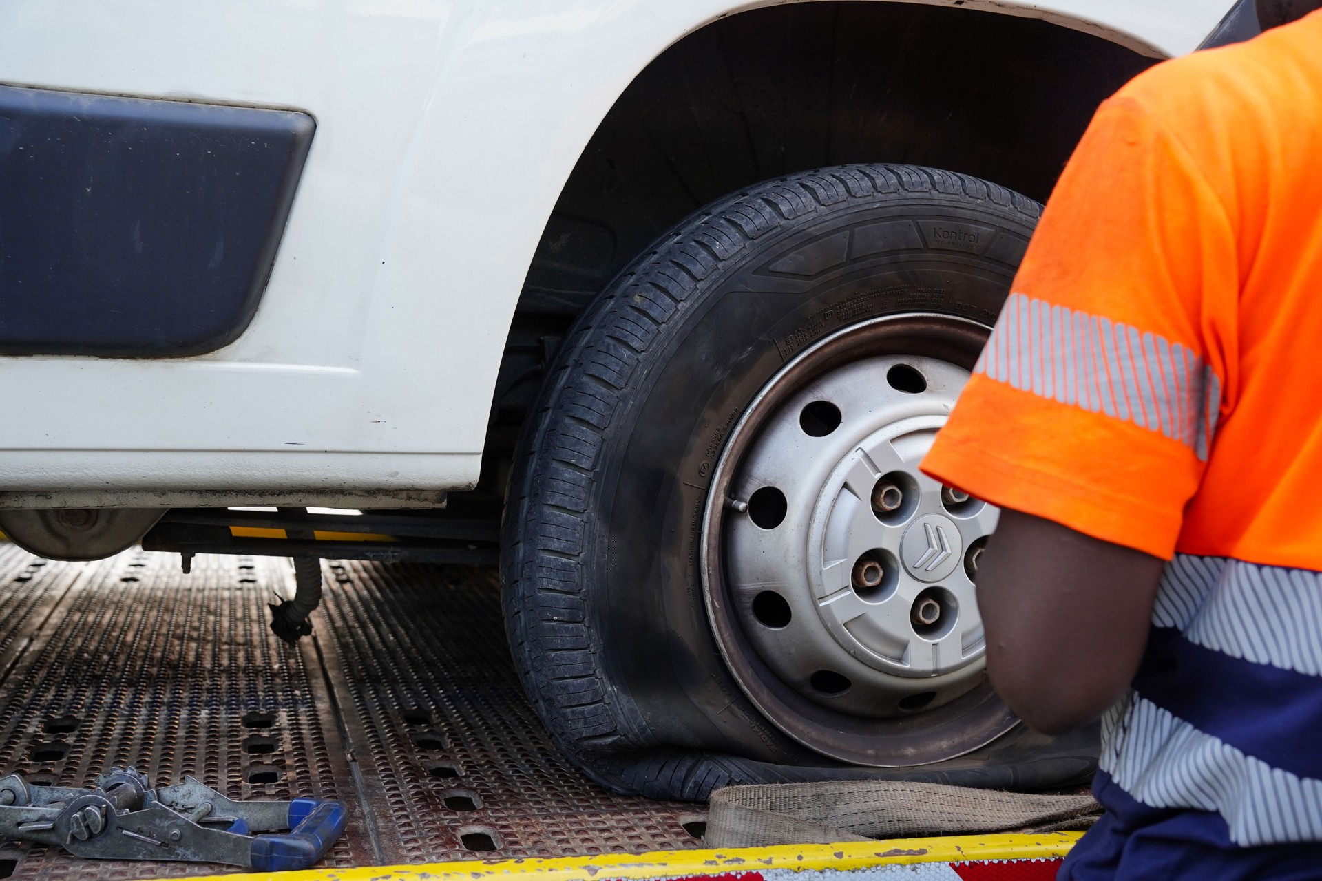roadside assistance of a vehicle. A tow truck takes away a van with a flat tire. Car insurance service for emergency